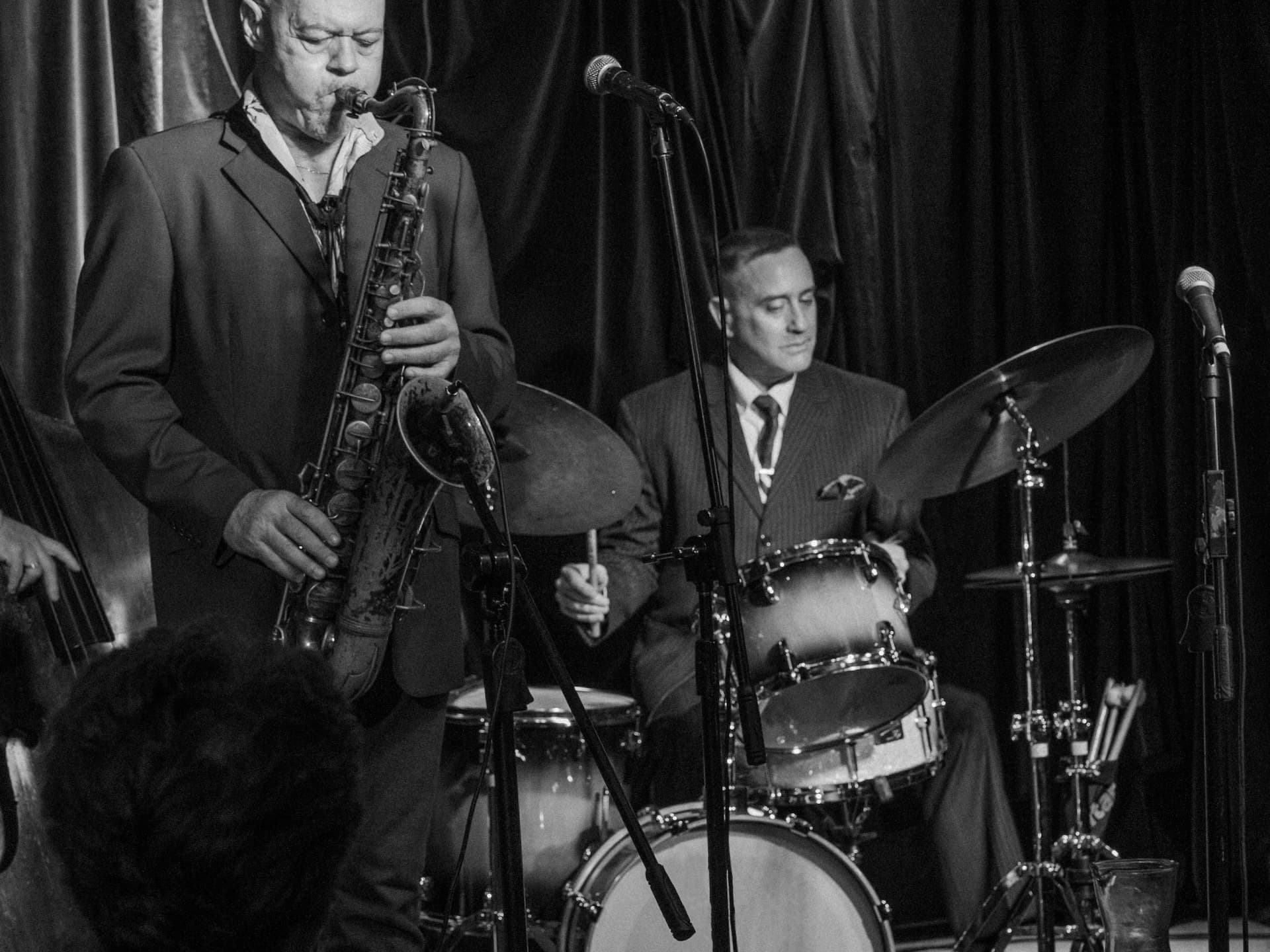 saxophone player and drummer performing B&W