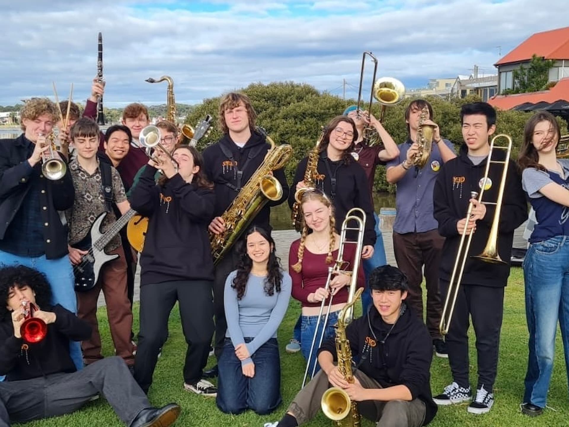 young jazz musicians posing with instruments outdoors