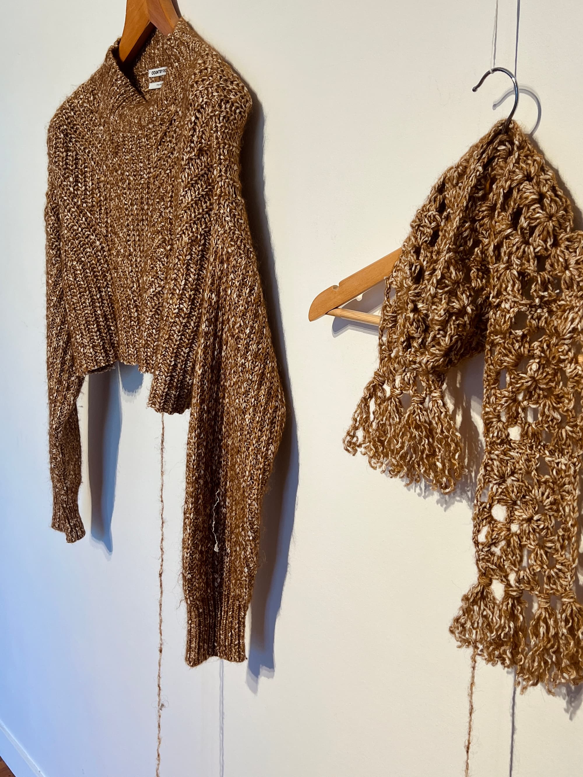 Jumper and scarf made out of recycled cotton and wool yarn hanging up