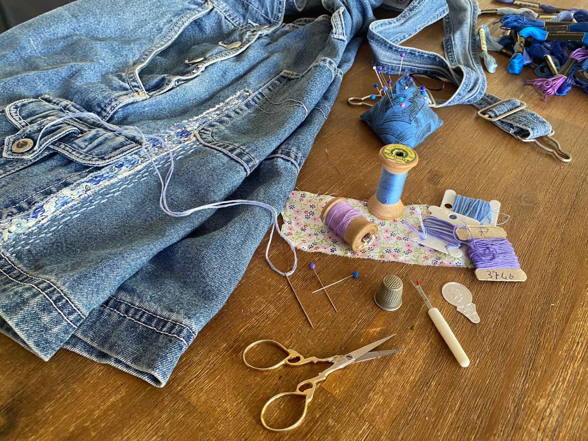 Someone sewing a denim jacket