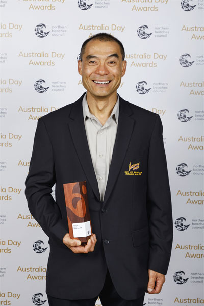 Kevin Lee standing with his award