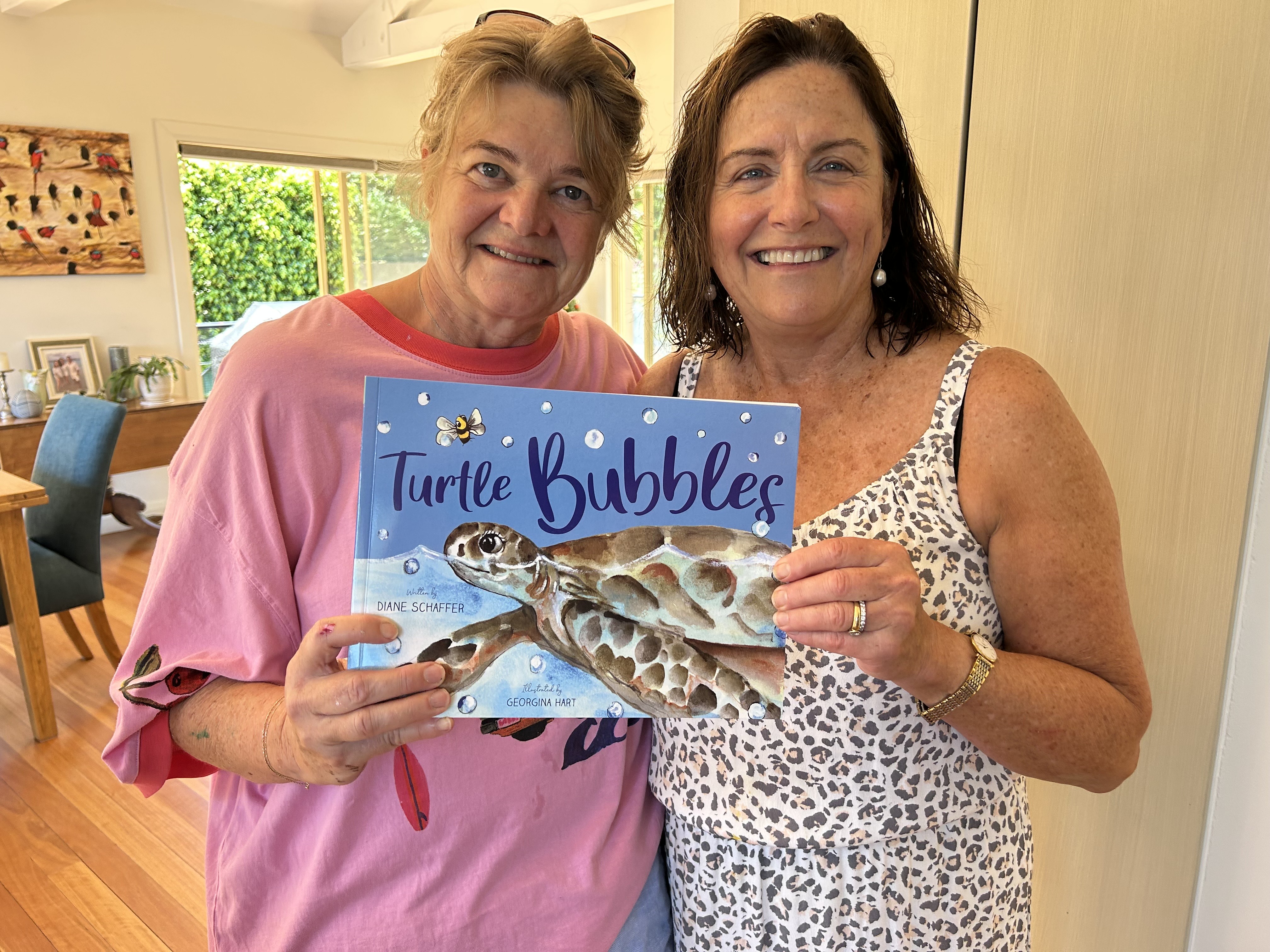 A photo of two women holding a picture book
