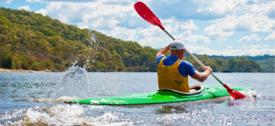 Kayaker paddling through water
