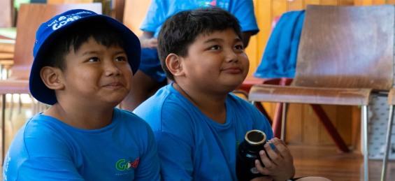 Two children smiling wearing blue tshirts