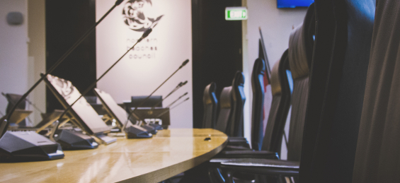 boardroom table with chairs and microphones