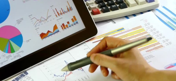 graphs on tablet scren, hand holding pen