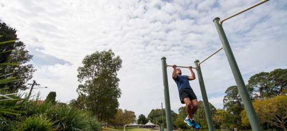 man doing pull ups in park