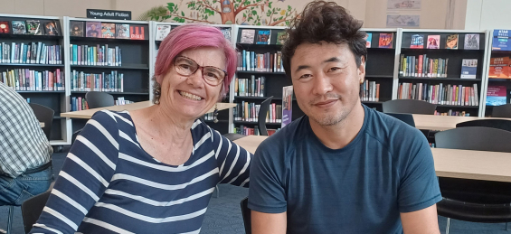 Two people smiling in the library