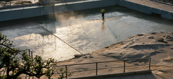 person cleaning empty ocean pool