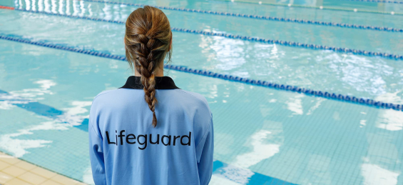 Lifeguard standing in front of the swimming pool