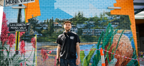 Artist Gus Eagleton standing in front of his artwork at Mona Vale Memorial Hall