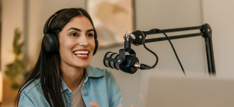 Person speaking into a mic recording a podcast