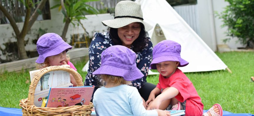 Early Childcare worker and children playing together