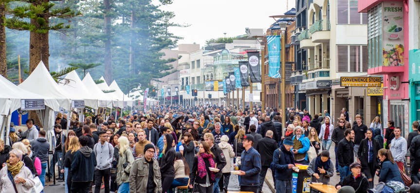 Group of people eating at market stalls