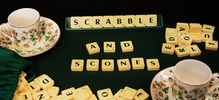 scrabble tiles spelling out scrabble and scones, with floral teacups around