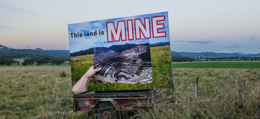 Artwork in the middle of field saying 'This land is mine'