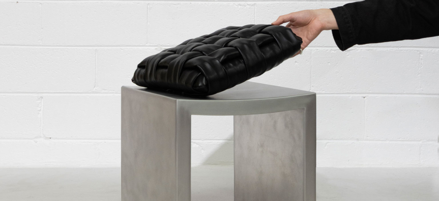 A vault stool with a hand holding a pillow