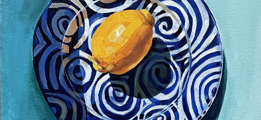 Painting of a lemon on a blue and white plate