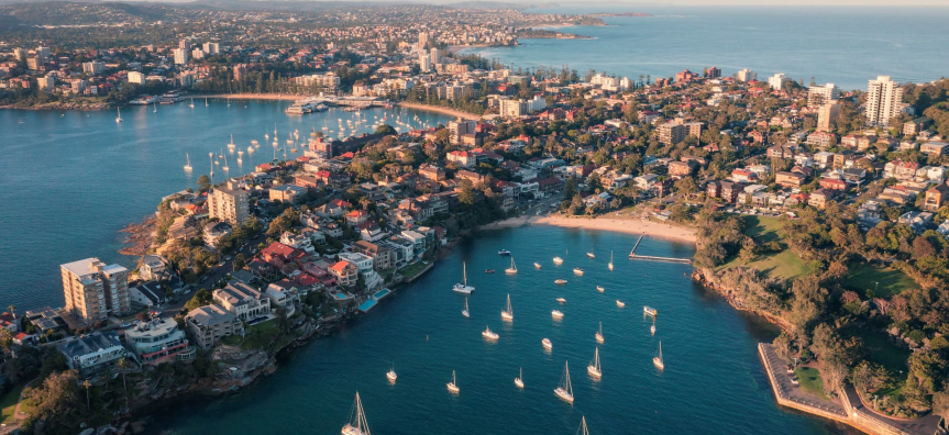 An aerial image of manly cove and manly wharf with Manly Beach in the background