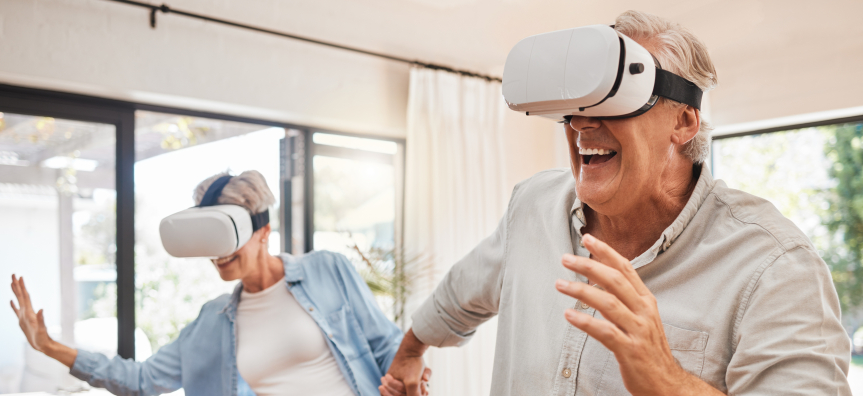 An older happy couple standing and experiencing a VR Headset each