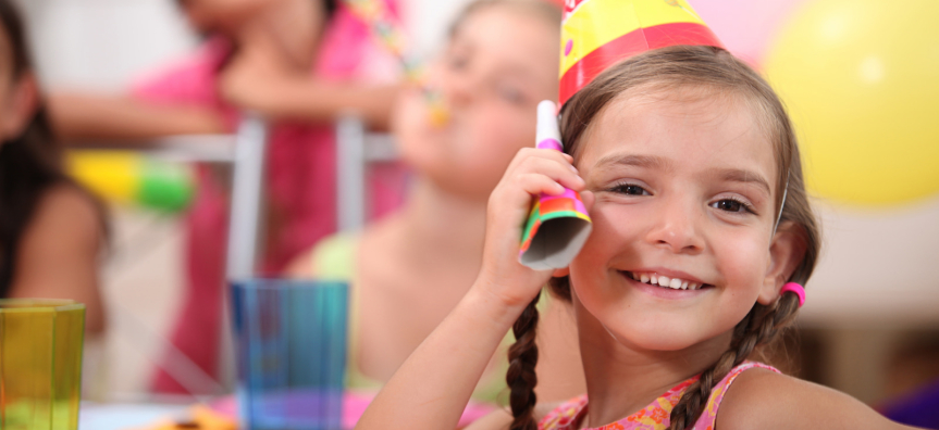 Child smiling wearing a party hat