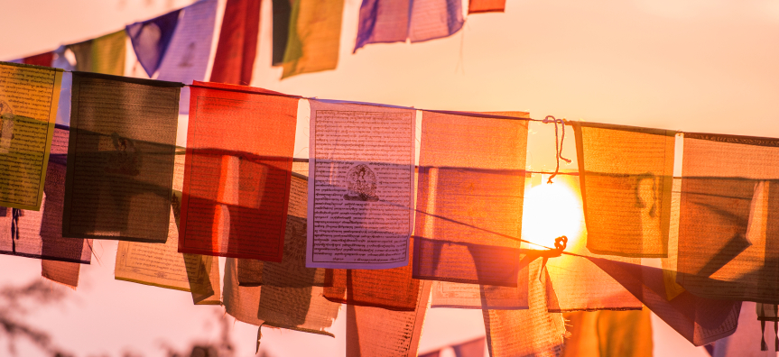 Colourful Tibetan flags and sunset in the summit of a Himalayan mountain