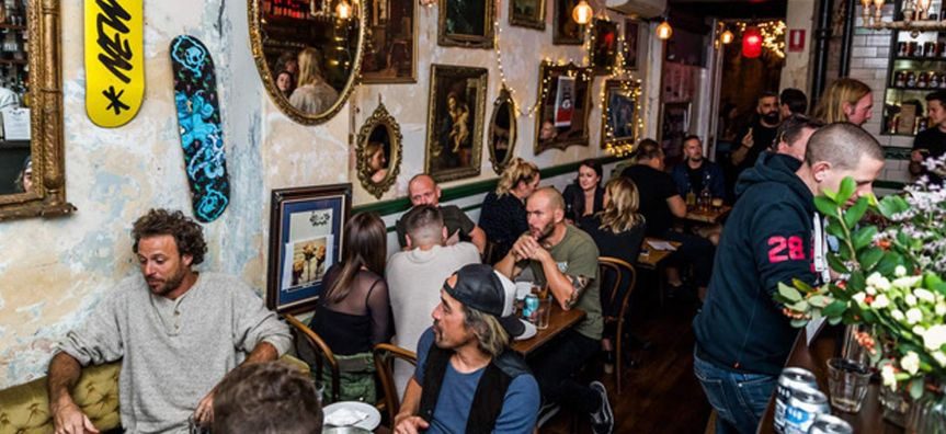 Inside the Belgrave Cartel restaurant, a crowd sits at cosy tables, enjoying each others company and the good vibes. An eclectic assortment of mirrors, artworks, and trinkets adorn the walls.