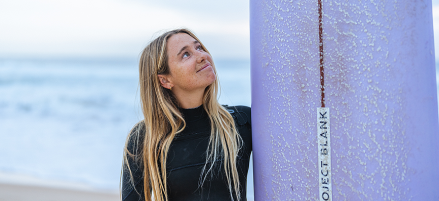 Surfer Tully White looks up at her surfboard