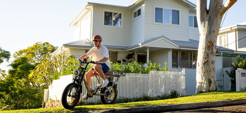 Person riding an e-bike outside a house