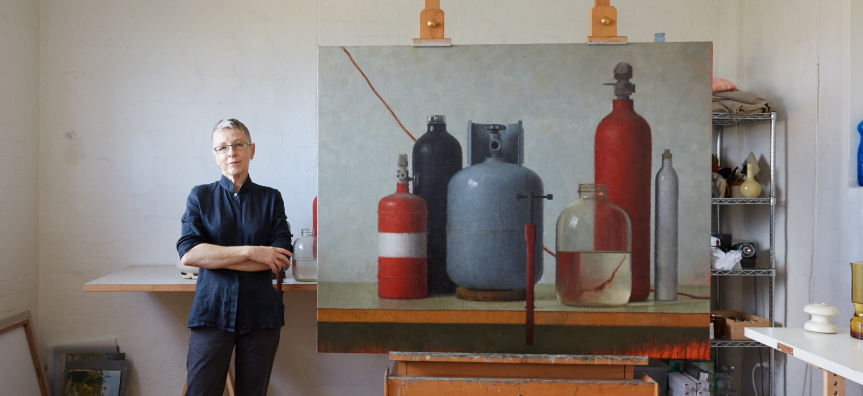 Artist Jude Rae with painting in studio 