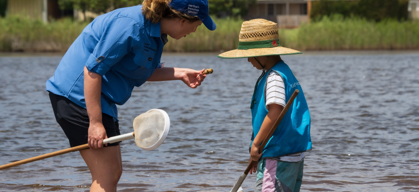 adult showing shell to child 