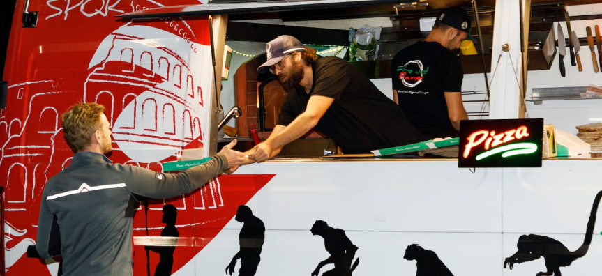 man serving pizza from a food truck