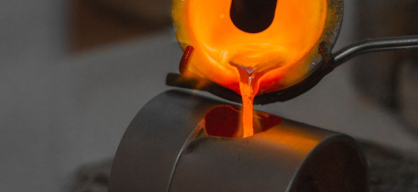 close up on molten metal being poured into a mold for a ring