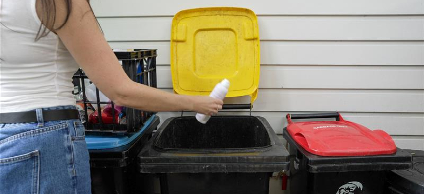 Person standing in front of the rubbish bins