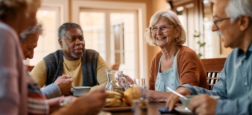 Seniors sitting around a table drinking 