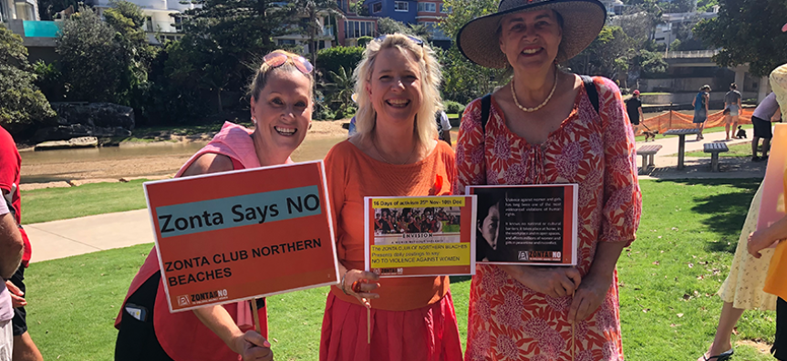 3 people holding signs standing at a 16 days of activism event