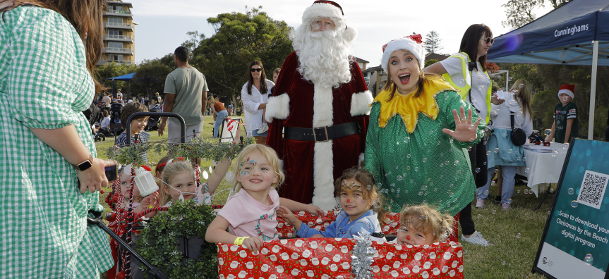 Santa, elf helper and children at Christmas by the Beach