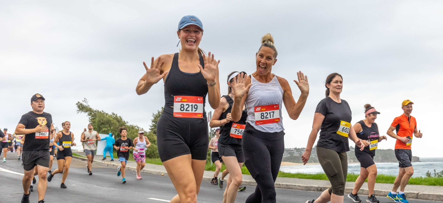Competitors running by the beach during Sun Run 2024