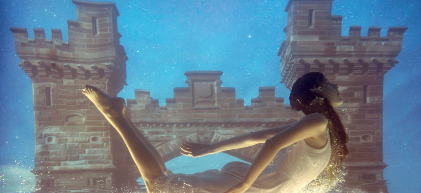 women slightly submerged in water in front of Northbridge Bridge by Tamara Dean