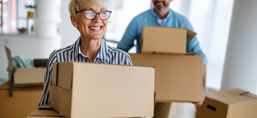 happy people carrying moving boxes