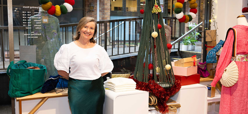 The owner of the Knitting Room stands in her shop with festive decorations