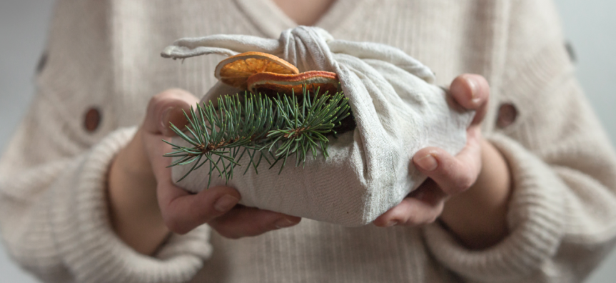 lady giving a gift wrapped sustainably