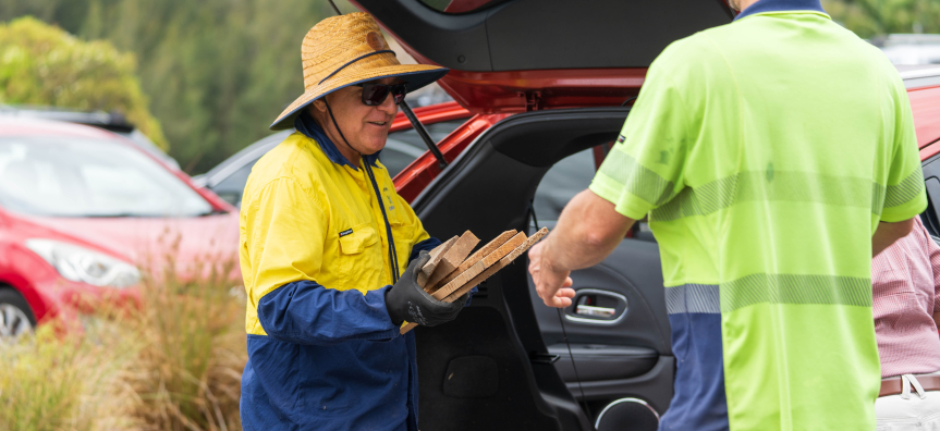 Staff collecting timber from car boot