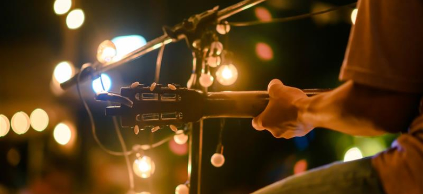 Acoustic guitarist surrounded by lights