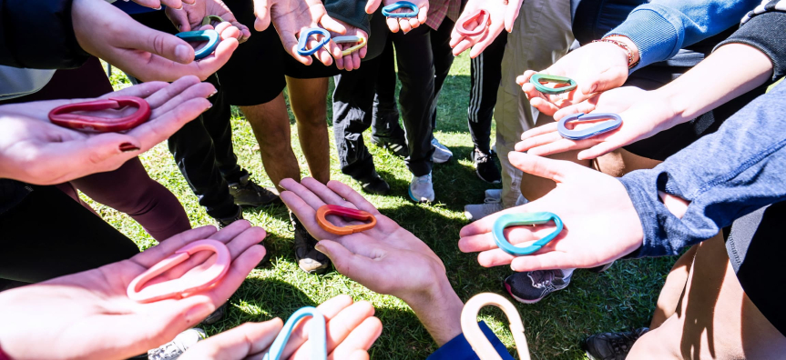 A hand holding an arts piece outside