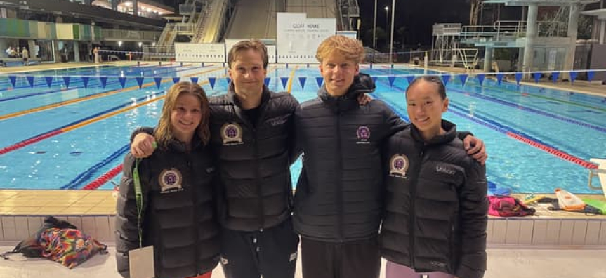 4 winning swimmers stand pool side