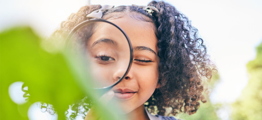 Girl looking through a magnifying glass