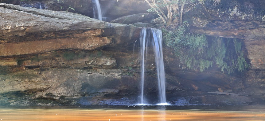 Waterfall streams from rocks into lake of water at Irrawong Falls