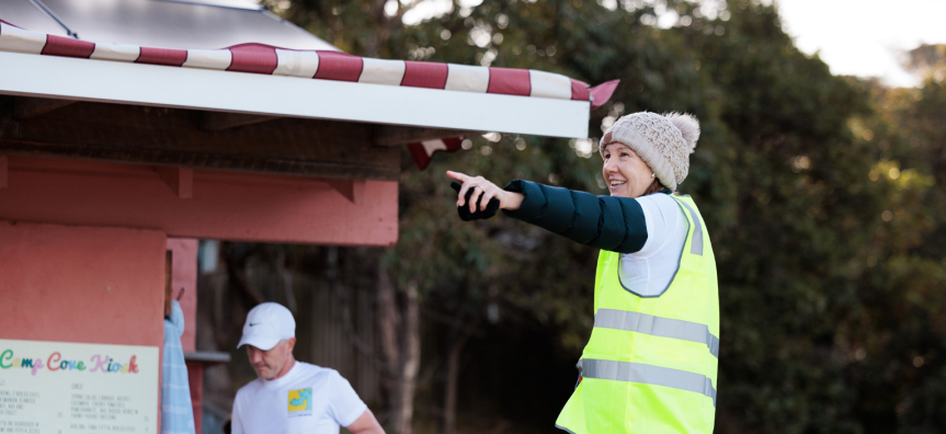Bondi to Manly Volunteer giving directions to runners