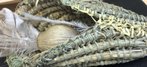 photo of a woven object holding feathers